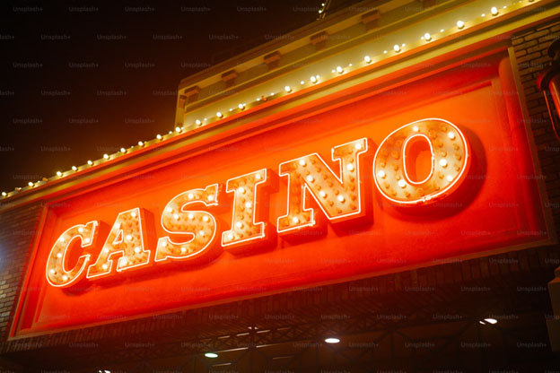 A brightly lit CASINO sign with glowing bulbs illuminates the night.